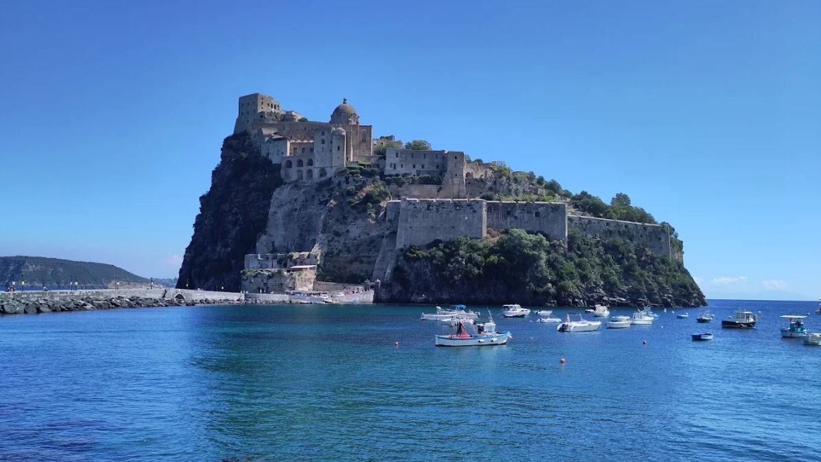 Il Castello Aragonese di Ischia visto dal mare, con le barche ormeggiate nel porticciolo